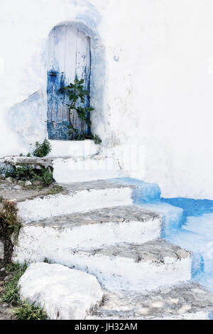 Stone staircase with old, wooden, blue door in Chefchaouen, Morocco. Stock Photo