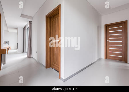 Interior of modern, white apartment with wooden doors Stock Photo