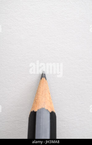 A graphite pencil, poised as if about to write or draw on blank white paper. Stock Photo