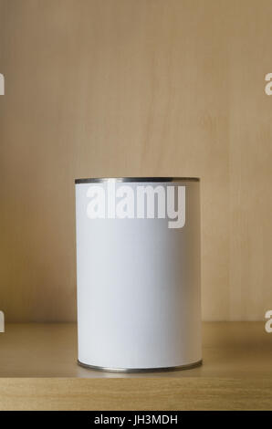 One single tin can (aluminum) with blank white label on shelf with copy space above. Stock Photo