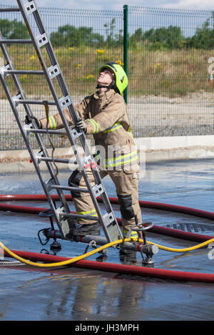 firefighter anchoring ladder at ground level Stock Photo