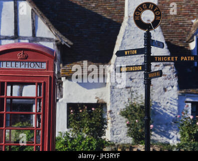 signpost and red public telephone box in Houghton village, Cambridgeshire, England, UK Stock Photo