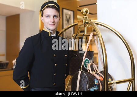 Young man in uniform serving in hotel Stock Photo