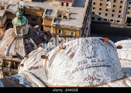 A papal crest on the outside of the dome of St Peter's Basilica, Vatican, Rome, Italy Stock Photo