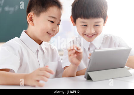 Two students using  digital tablet in classroom Stock Photo