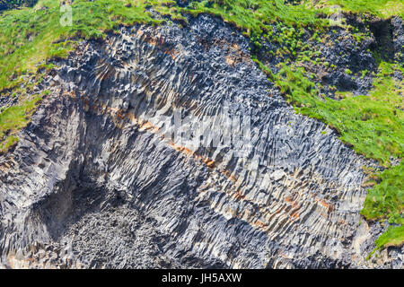 Exposed portion of cliff face showing basalt column formations on Reynisfjara beach in Iceland Stock Photo