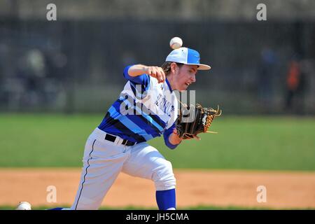 Pitcher delivering a pitch to an opposing hitter during a high school baseball game. USA. Stock Photo