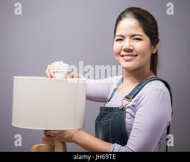 asian woman changing light bulb Stock Photo
