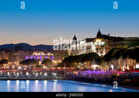 Promenade de la Croisette with the famous hotels Carlton and Martinez, Cannes, France at dusk Stock Photo