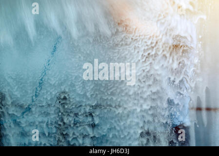 Man washing car in self-service car wash station, viewed from inside of the vehicle, selective focus Stock Photo