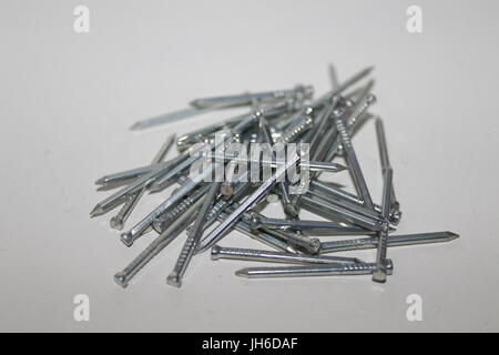 Disordered pile of wood nails on white background Stock Photo