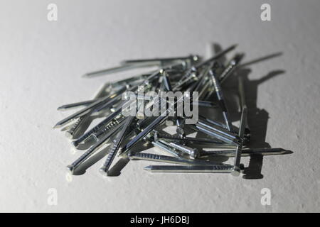 Disordered pile of wood nails on white background Stock Photo