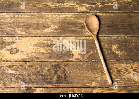 Wooden spoon on a weathered boards background with space for type Stock Photo