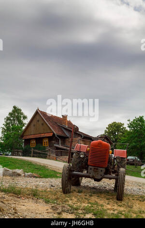 Rustic tractor and house on a cloudy day Stock Photo - Alamy