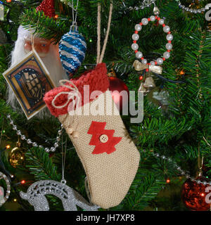 Christmas stocking and Christmas tree decorations hanging on the Christmas tree branches. Selective focus. Stock Photo