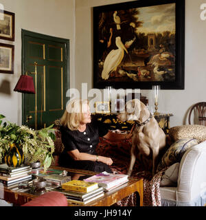 Woman and her dog sitting on sofa in the living room Stock Photo