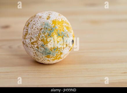 Lemon covered with mildew on a light wooden background. Copy space Stock Photo