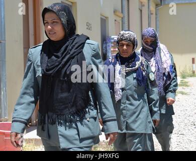 Tirin Kot, Afghanistan. 13th July, 2017. Afghan policewoman Masouma walks with her colleagues at the workplace in Tirin Kot, Uruzgan province, Afghanistan, July 7, 2017. Masouma has been working in the police force for the past 13 years and presently she is the commander of 23 female police personnel in Tirin Kot city. In conservative Afghan society, people particularly in the countryside regard women working outside of their family home as a 'taboo. Stock Photo