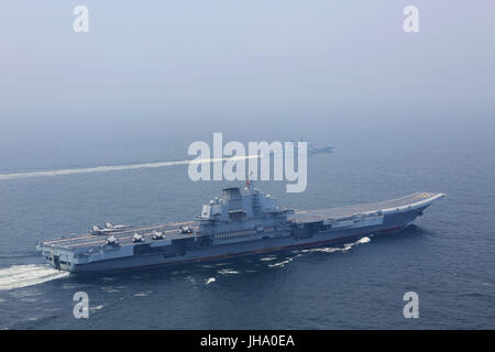 Aboard Liaoning Aircraft Carrier. 13th July, 2017. A flotilla including China's aircraft carrier Liaoning (Bottom) embark on a new training mission upon arrival at an unidentified sea area, July 13, 2017. Chinese aircraft carrier formation conducted coordination training on Thursday. Credit: Zeng Tao/Xinhua/Alamy Live News Stock Photo