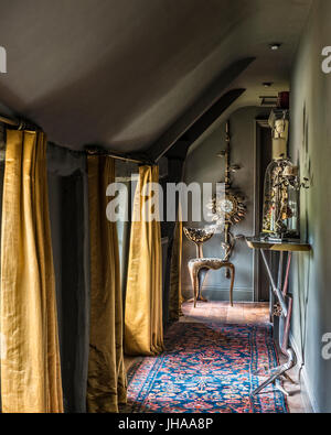 Hallway with yellow curtains and patterned rug Stock Photo