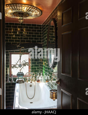 Chandelier over bath with green tiles Stock Photo