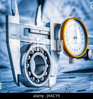 Metal vernier caliper and Ball bearings on technical drawing a blue toning Stock Photo
