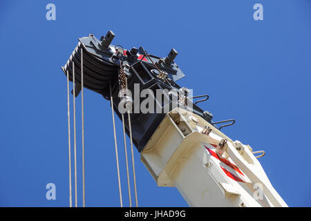 truck crane detail boom with hooks and scale weight above blue sky Stock Photo