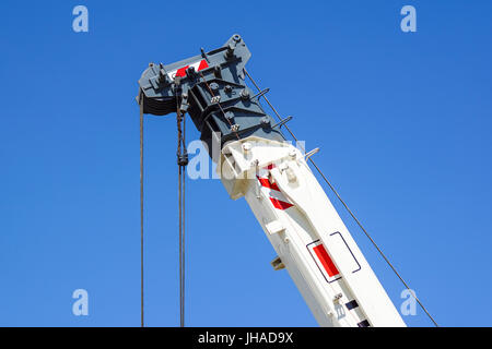 truck crane detail boom with hooks and scale weight above blue sky Stock Photo