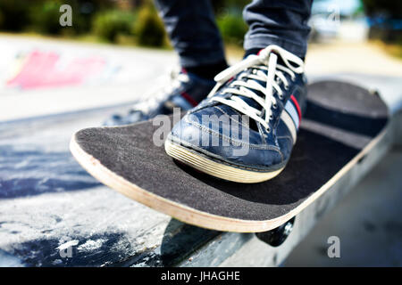 closeup of a young caucasian man skateboarding in an outdoors skate park Stock Photo