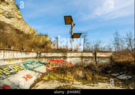 empty old overgrown run-down swimming pool with jumping tower, part of former luxurious site named Barrandov, built by V.M. Havel near city of Prague Stock Photo