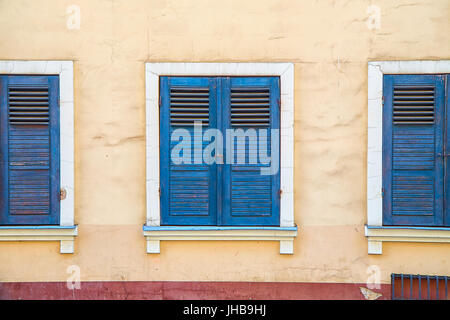Closed windows with old blue shutters. Part of the facade of the building in the old town Riga, Latvia Stock Photo