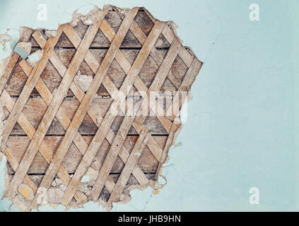 Part of the wall of the old house with partially peeled plaster where the wooden crate can be seen Stock Photo