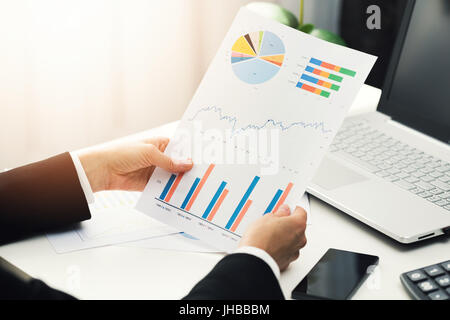 woman at office analyzing business financial graph reports Stock Photo