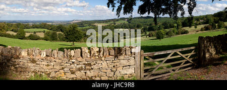 View over Cotswold landscape and drystone wall with wooden five bar gate, Saintbury, Cotswolds, Gloucestershire, England, United Kingdom, Europe Stock Photo