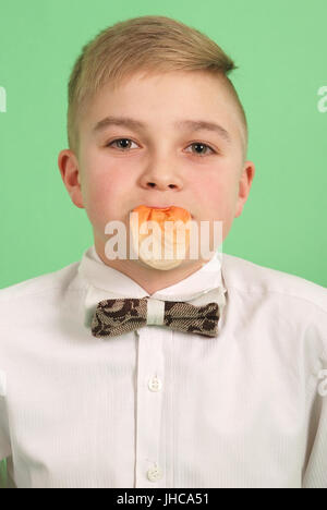 Boy blowing a bubblegum bubble isolated on green Stock Photo