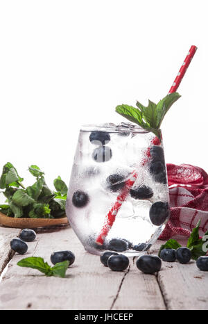 Summer cold drink with blueberry, mint and ice in glass on white wooden background Stock Photo
