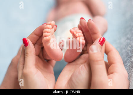 Baby feet in mother hands Stock Photo