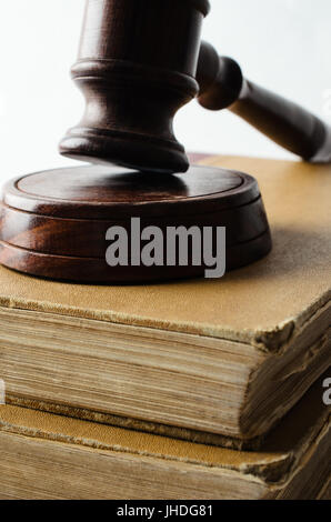 Close up law concept shot of old books stacked and topped with wooden gavel on white background. Stock Photo