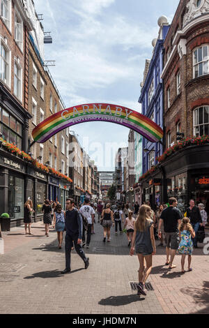 Crowds of pedestrians, locals and tourists, in Carnaby Street, a pedestrianised shopping street in Soho in the West End of London, England. Stock Photo