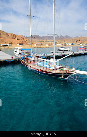 SHARM EL SHEIKH, EGYPT -  DECEMBER 4: The sail yacht with tourists is near pier in harbor of Sharm el Sheikh. It is popular tourists destination on De Stock Photo