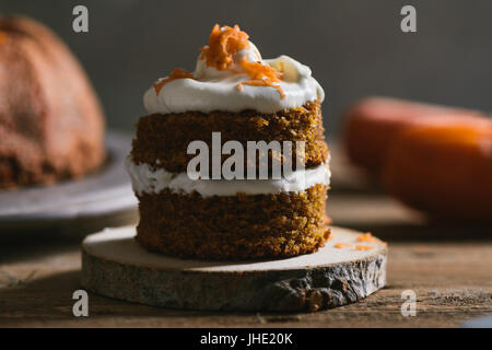 Mini carrot cake, stuffed with cream cheese, on rustic wood plate, close up Stock Photo