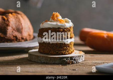 Mini carrot cake, stuffed with cream cheese, on rustic wood plate, close up Stock Photo