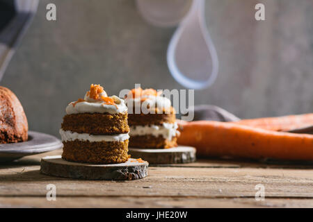 Mini carrot cake, stuffed with cream cheese, on rustic wood plate, close up Stock Photo