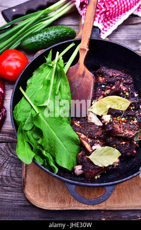 Fresh Pork In A Black Pan, Placed On A Wooden Table With Spices Placed 