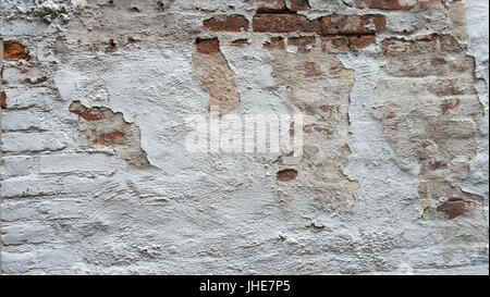 distressed painted white brick wall with chipped paint Stock Photo