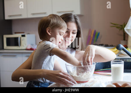 mother and son prepare pie with flour Stock Photo