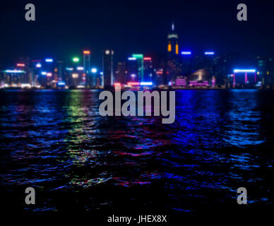 view of skyscrappers  shining with colourful lights in Hong Kong bay at night Stock Photo