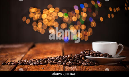 Coffee cup and coffee beans on a wooden table and bokeh background Stock Photo