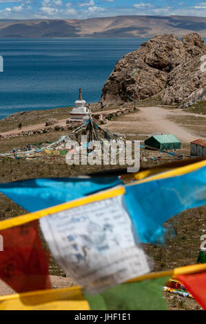 Prayer flags at the entrance of the sacred lake of Nam Tso (4700 m, one of the largest lakes in the world) located in the northern tip of Tibet. Stock Photo