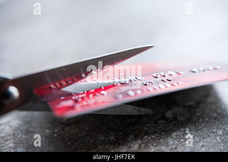 Credit card being cut with scissors, close up with copy space Stock Photo